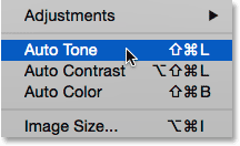 Selecting the Auto Tone command from under the Image menu in Photoshop. Image © 2015 Photoshop Essentials.com